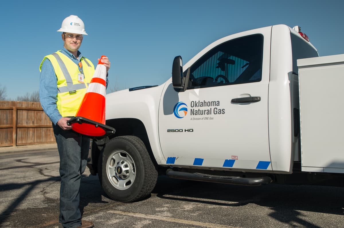 Oklahoma Natural Gas employee and truck with safety cone